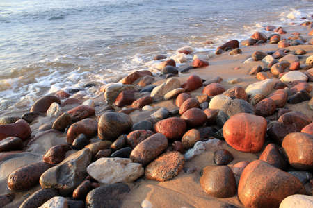 Sea pebbles on the shores of the Baltic Sea at sunset.の写真素材