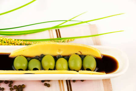 green olives in the sauce on ceramic plate