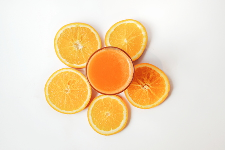 A glass of orange juice with orange slices on white background. Vitamins on top viewの写真素材