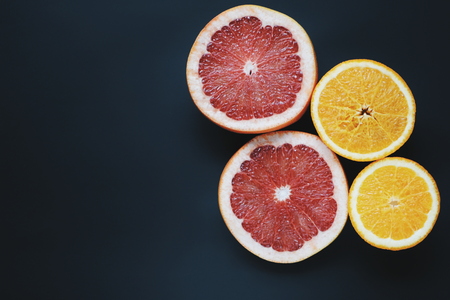 Grapefruits and oranges on black background. Slice fruits wallpaperの写真素材