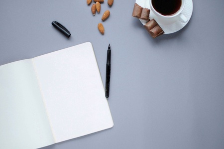 Study stuff. Education background. Stationery. Aspects of education. Food for brain.  Opened marker, opened notebook, coffee, almonds and chocolate on the table.の写真素材