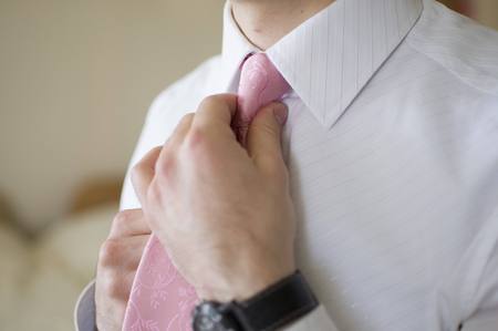 Man corrects his tie. Male in white shirtの写真素材