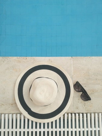 Straw hat with sunglasses near the poolの写真素材