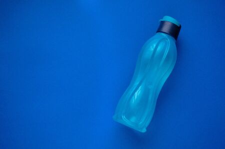 Eco bottle classic blue color of the year 2020. Attribute of a healthy lifestyle. Flat view with copy space. Tool for fitness. Minimalism.の写真素材