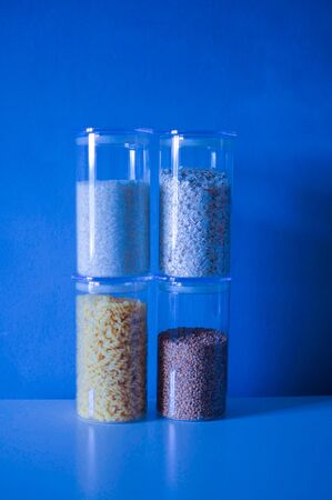 Four glass jars of different cereals on classic blue background color of the year 2020の写真素材