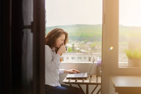 Woman remote working from home at balcony in time of coronavirus quarantine.の写真素材