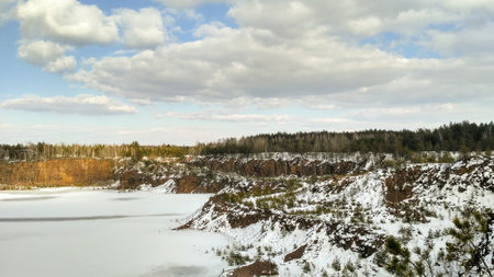 Beautiful winter landscape of frozen old quarry. Borrow pit in winter. Sunny dayの写真素材