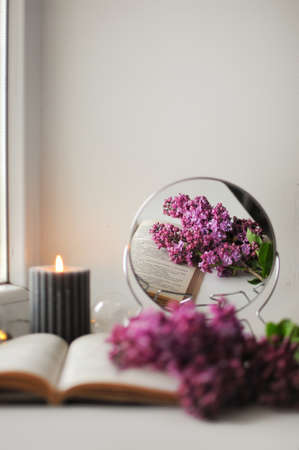 Beautiful composition with opened book and lilac flowers. Romantic wallpaper.