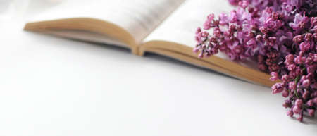 Banner with opened book and lilac flowers composition. Romantic atmosphere.の写真素材
