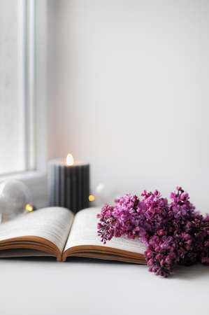 Beautiful composition with opened book and lilac flowers. Romantic wallpaper.の写真素材