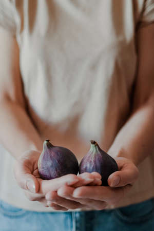 A young girl is holding fresh figs in her hands. Depth of fieldの写真素材