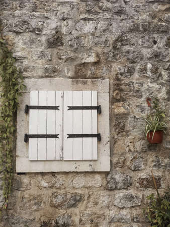 Nice wooden window on a stone wall with plants in Budva, Montenegroの写真素材