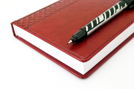 Pen and brown diary on the white backgroundの写真素材