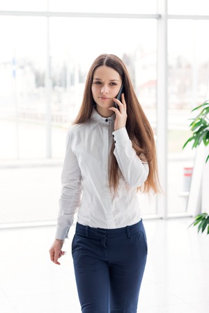 Young happy business woman talking on the mobile phone and smilingの写真素材