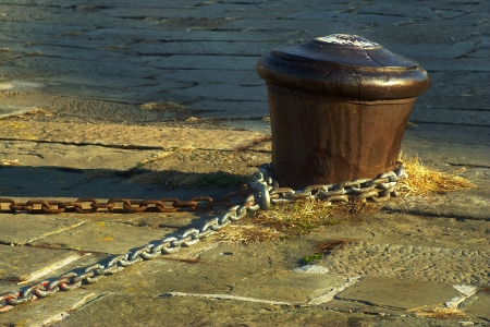 Rusty bollard and chains on a pier at Trieste, Italy の写真素材