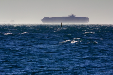 A container ship in the gulf of Trieste while a strong wind is blowingの写真素材