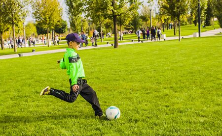 Russsia,Krasnodar,30 september 2018: boy on grass beats the ballのeditorial素材