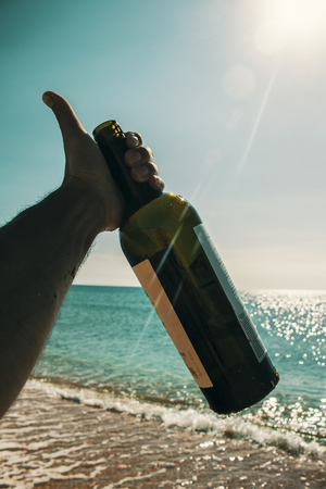 hand holding a bottle on the sky backgroundの写真素材