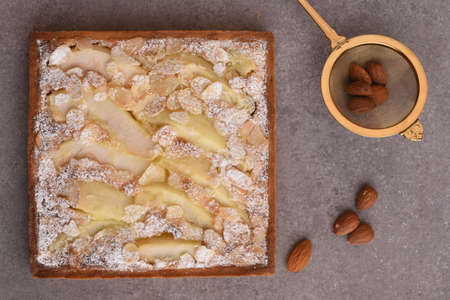 Delicious apple pie with cinnamon and almonds on grey table, flat layの写真素材