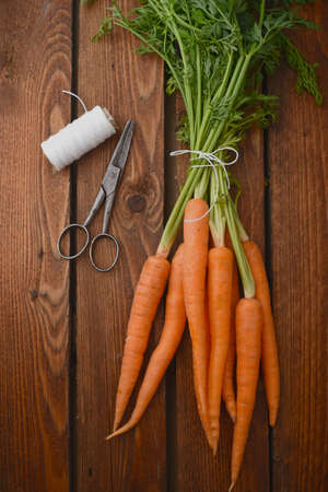 Bunch of fresh carrots on the wooden tableの写真素材