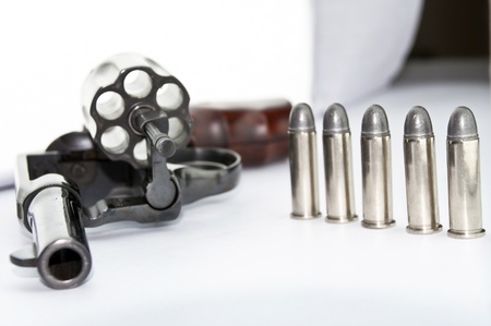 handgun revolver with bullets on white background