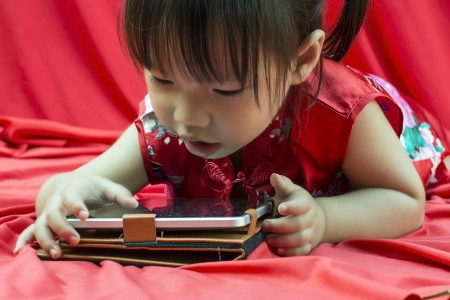 China girl in traditional Chinese red Tang suit greeting and play smartphoneの写真素材
