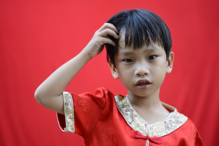 China boy in traditional Chinese red Tang suit greetingの写真素材