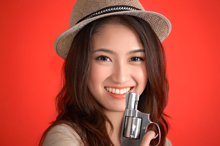 Young asian cute woman with handgun revolverの写真素材