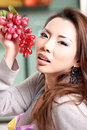 Happy asian woman cooking in the kitchenの写真素材