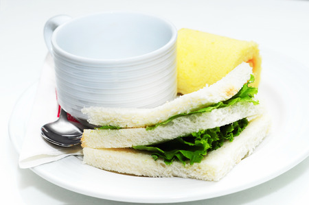 Hot coffee in white cup with sandwich ham&cheese and sweetmeatの写真素材
