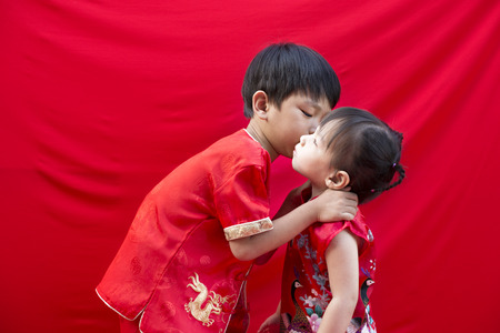 China boy and girl  in traditional Chinese red Tang suit greetingの写真素材