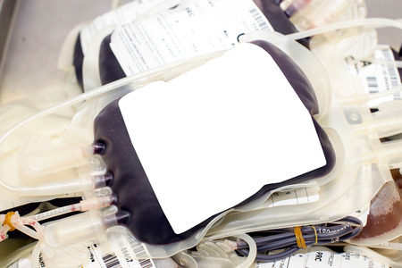 Close up bag of blood and plasma and rubber tube isolated on Red backgroundの写真素材