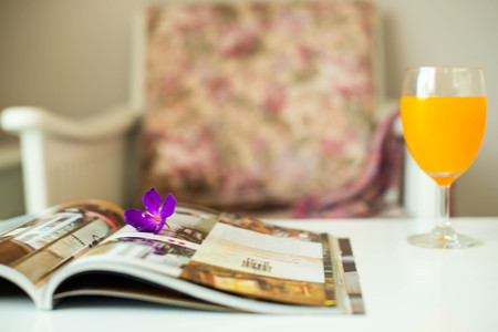 Comfortable armchair with pillows and blanket against white wall backgroundの写真素材