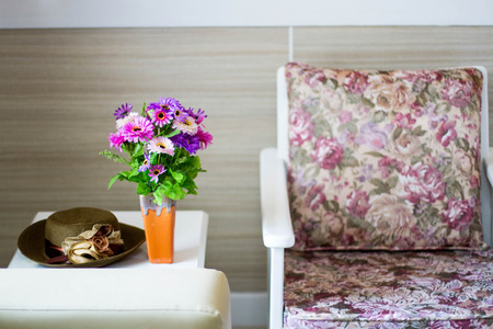 Comfortable armchair with pillows and blanket against white wall backgroundの写真素材