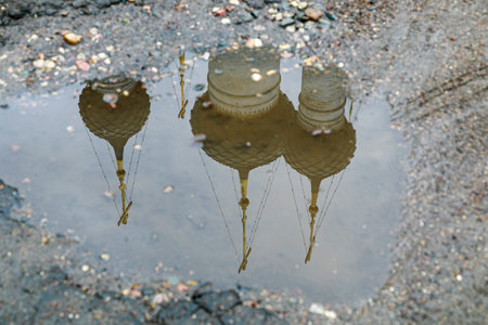 Reflection of the domes of the church in a puddle on the road in summer.の写真素材