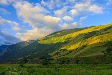 High mountains of the Caucasus with beautiful views. Green vegetation and dense forest above a blue sky. A great fascinating landscape.の写真素材