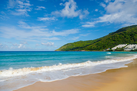 Beautiful sea Sunny landscape on the beach. Light waves of blue color spread all over the beach, smoothly smoothing the Golden sand. In the distance, a hotel can be seen near the coastline.の写真素材