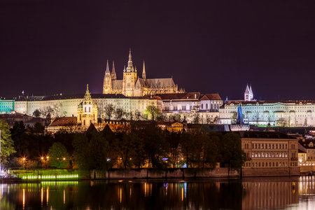Charles Bridge in Prague in the evening with colorful lights from lanterns. In the river the reflection of the evening illuminations.の写真素材