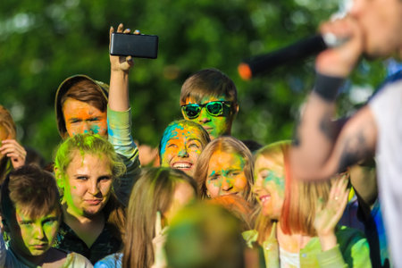 Russia, Moscow - June 25, 2017. Portrait of a girl with bright flowers on her face. Laughs with happiness. Holi is a traditional holiday in Indiaのeditorial素材