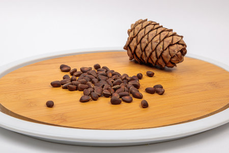 The fruit of Siberian cones - pine nuts on a kitchen cutting board, is a delicious, nutritious and healthy product.の写真素材