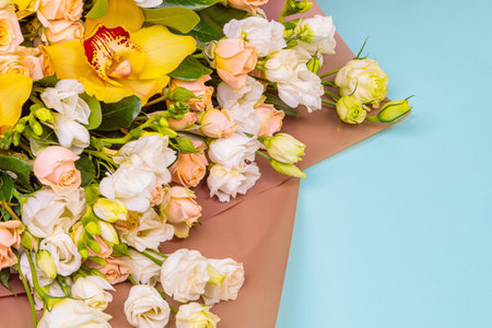 Fresh bouquet in pastel shades of pink, white, green, yellow. Homogeneous pink, blue background. Delicate bouquet for a woman.の写真素材