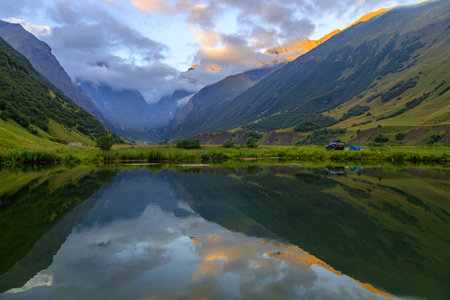 High mountains of the Caucasus with a beautiful view. Green vegetation and shrubs on sharp rocks, between the mountains of the lake. Magnificent mesmerizing landscape.の写真素材