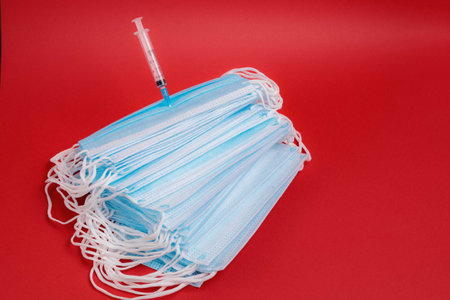On the table is a medical mask with a syringe and medicineの写真素材