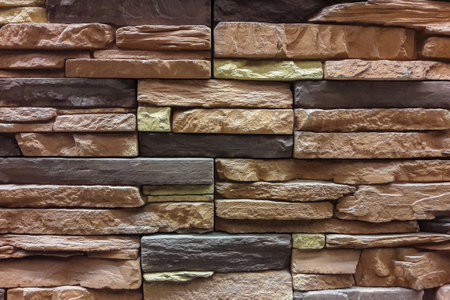 The wall is made of multi-layered natural stone. Stone for building a house.