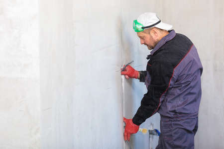 An electrician is laying a cable in an electrical wiring ditchの写真素材