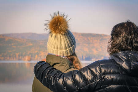Young couple looks into the distance to the opposite shore of the lake