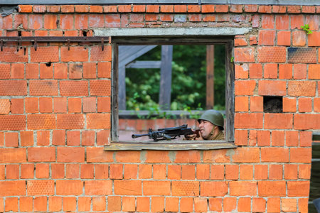 Reconstruction of the times of the Great Patriotic War. A Russian soldier fires a machine gun in an ambush. Moscow Russia September 16, 2017のeditorial素材