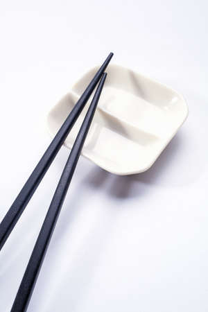 Black wooden sushi sticks with sauce saucer. View from aboveの写真素材