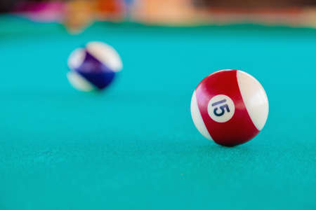 Playing with striped balls on a billiard table. Close-up