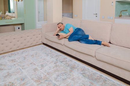 An adult man browses social networks on a mobile phone.の写真素材